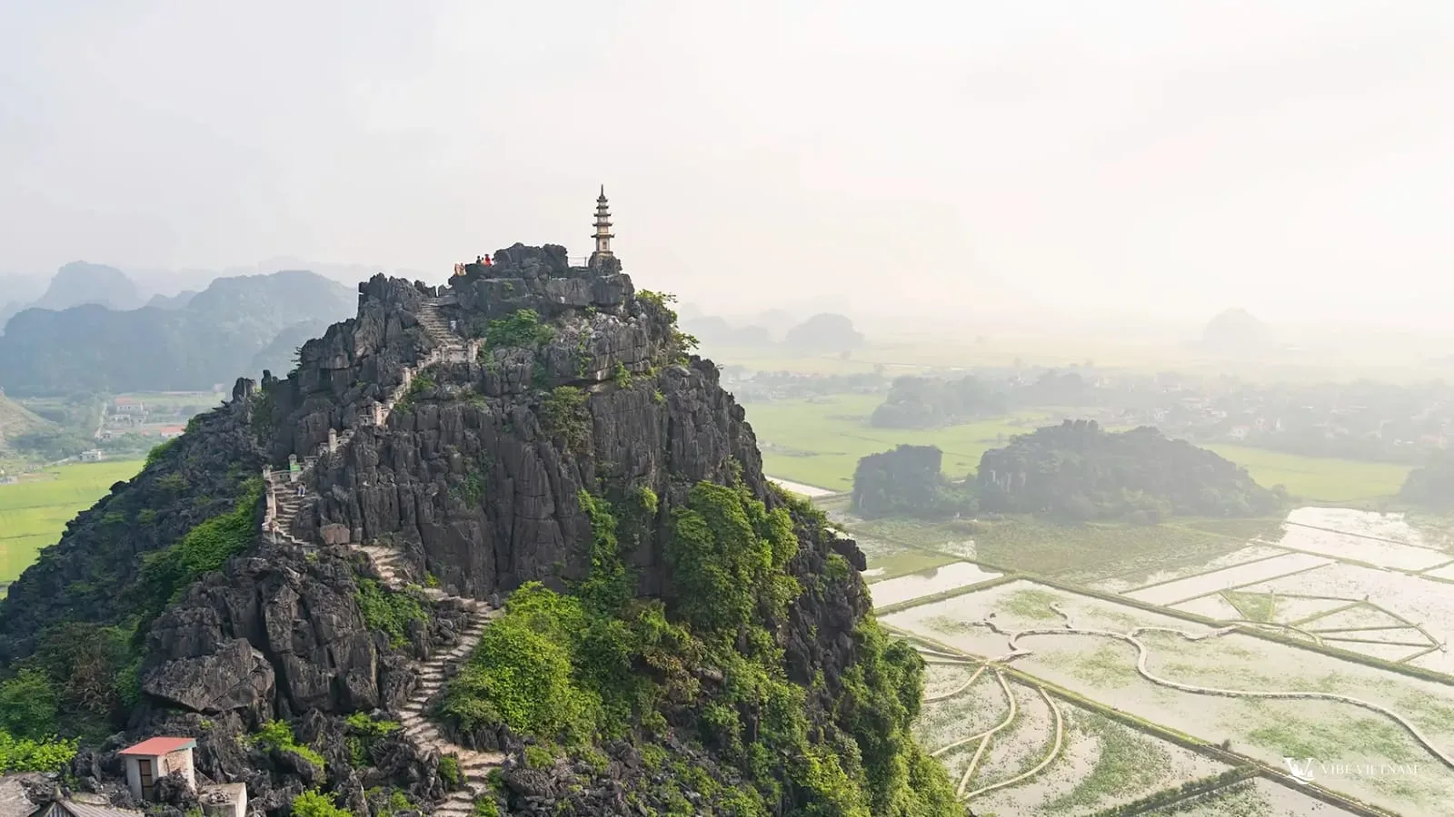 The stone steps leading up to the Hang Mua viewpoint above rice fields and limestone outcrops