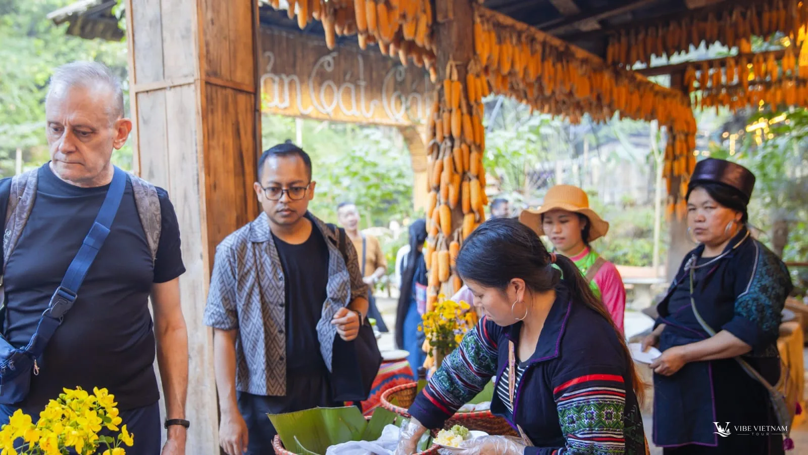 Travellers trying local food from a Hmong vendor in Sapa