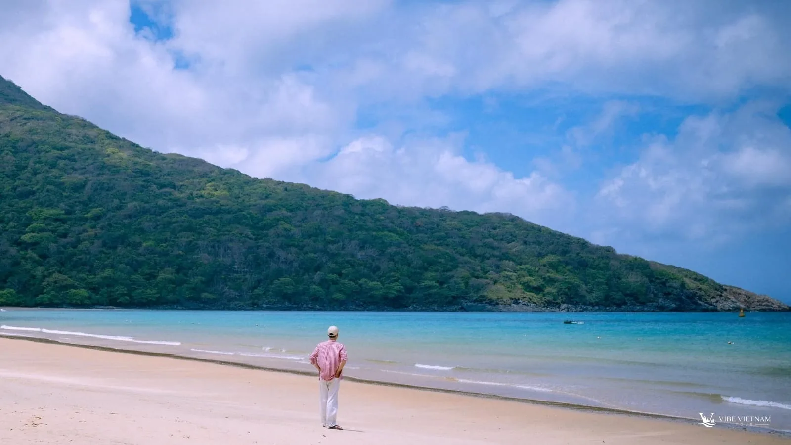 Quiet sand and green hills at Dam Trau Beach, Con Dao